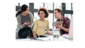 Three young professionals having a discussion in a modern office, using a smartphone and tablet.